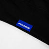 Close up view of the blue woven label in the HOLOCENE black hoodie from PHOSIS Clothing