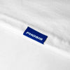 Load image into Gallery viewer, Close up view of the blue woven label in the ATLANTIC white long sleeve from PHOSIS Clothing